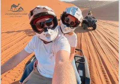 two people riding on a quad bike in the desert at Overnight Camp Erg Chebbi in Merzouga