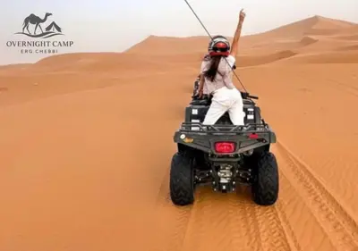 a person on a quad bike in the desert at Overnight Camp Erg Chebbi in Merzouga