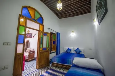 a bedroom with two beds and a stained glass window at dar Benfares rcif in Fès