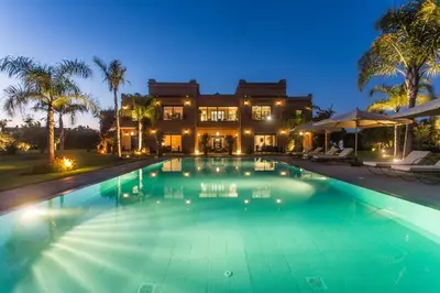 a large swimming pool in front of a house at La Villa Rose Anna in Marrakech