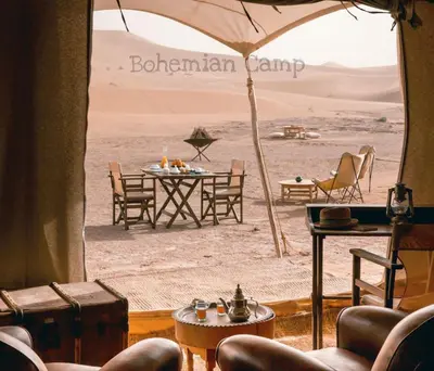 a room with a table and chairs in the desert at Merzouga Bohemian Camp in Merzouga