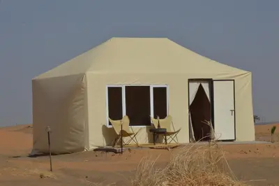a white tent in the middle of the desert at Merzouga Bohemian Camp in Merzouga