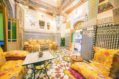 a living room with a couch and a table at Palais Fes Yahya - family hosting in Fès al Bali