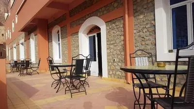 a patio with tables and chairs in a building at Auberge Restaurant Fatihi Freres in Tinerhir