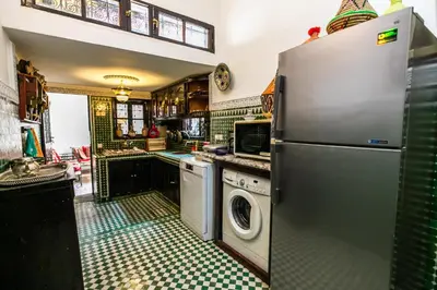 a kitchen with a refrigerator and a washing machine at Dar Ben Daoud avec piscine et terrasse privee in Fès