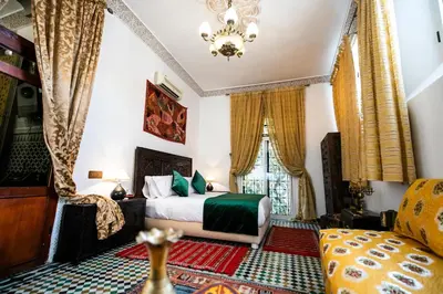 a hotel room with a bed and a couch at Dar Ben Daoud avec piscine et terrasse privee in Fès