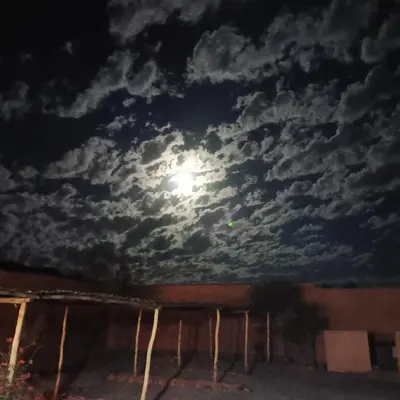 a full moon in a cloudy sky at night at LESCALE DE OUARZAZATE in Ouarzazate