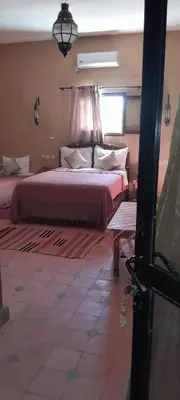 a bedroom with a large bed and a window at LESCALE DE OUARZAZATE in Ouarzazate