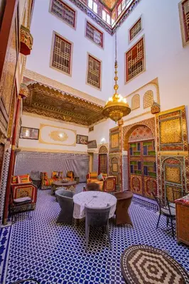 a room with tables and chairs and a ceiling at Riad Fes Hayat - Confort Stay in Fès