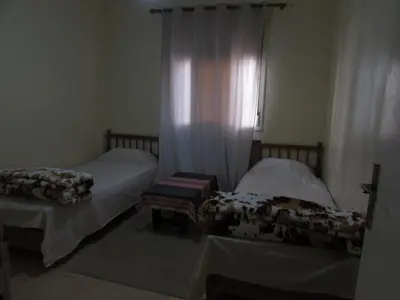 a bedroom with two beds and a window with curtains at Bed and breakfast in Ifrane