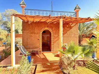 a house with an archway and a patio at Oasis Tilogui-Luxury Hotel Restaurant and Desert Excursions In Zagora in Zagora