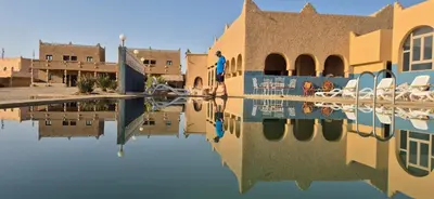 a reflection of a building in a body of water at Takojt in Merzouga