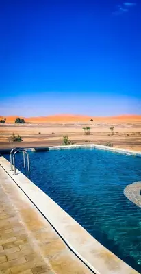 a swimming pool in the middle of the desert at Takojt in Merzouga