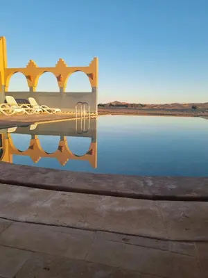 a pair of wedding rings sitting on top of a body of water at Takojt in Merzouga