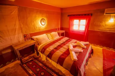 a bedroom with a bed with two towels on it at Takojt in Merzouga