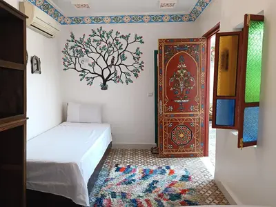 a room with a bed and a door with a rug at Riad Safir Medina Fes in Fès