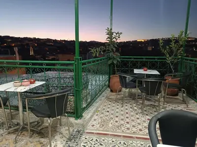 a patio with tables and chairs on a balcony at Riad Safir Medina Fes in Fès