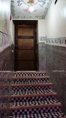 a wooden door in a room with stairs in front at Riad Safir Medina Fes in Fès