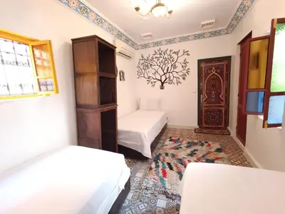 a room with two beds and a door at Riad Safir Medina Fes in Fès