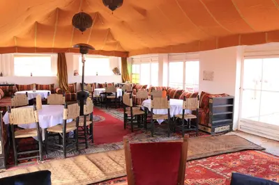 a restaurant with tables and chairs in a room at Luxury Berber Camp in El Gouera