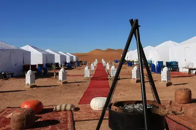 a row of tents in the desert with a red carpet at Luxury Berber Camp in El Gouera