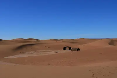 an old house in the desert with a sand dune at Luxury Berber Camp in El Gouera