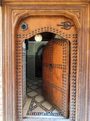 a wooden cabinet with a mirror in a room at Riad le petit ksar in Meknès