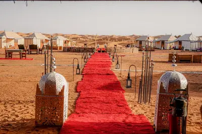 a red carpet in the middle of the desert at Desert Luxury Camp Morocco in Merzouga