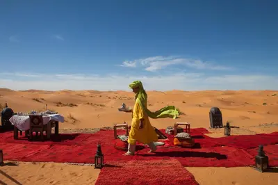 a woman walking in the desert at Desert Luxury Camp Morocco in Merzouga