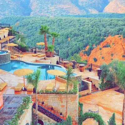 a resort with a pool and mountains in the background at Borj Des Cascades & Spa in Ouzoud