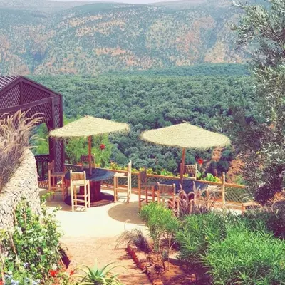 a patio with tables and umbrellas with a view at Borj Des Cascades & Spa in Ouzoud