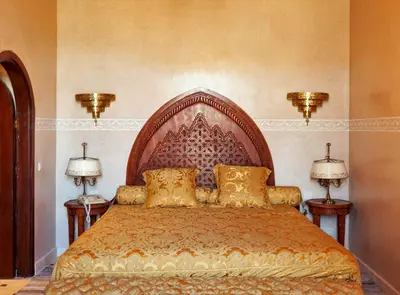 a bedroom with a large bed with two lamps at Borj Des Cascades & Spa in Ouzoud