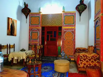a living room with a red door and a table at Hostel Rcif in Fès