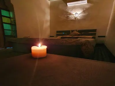 a candle sitting on a table in a room with a bed at Hostel Rcif in Fès