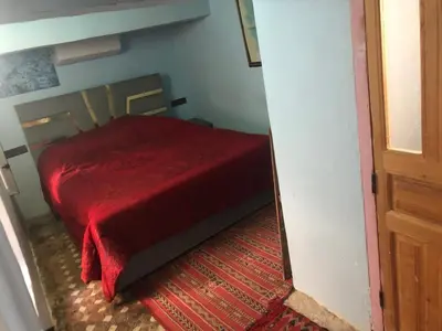 a bedroom with a red bed with a red blanket at Hostel Rcif in Fès