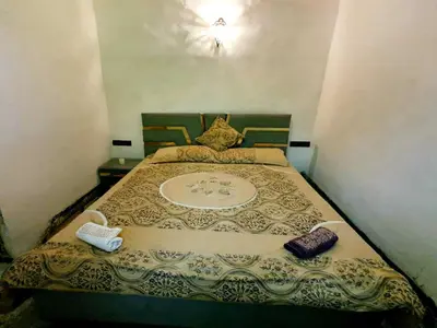 a small bedroom with a bed with two pillows at Hostel Rcif in Fès