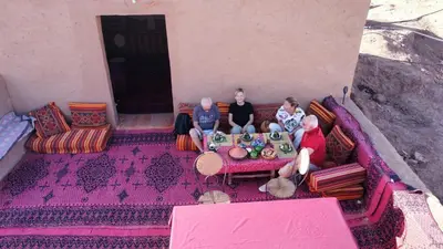 a group of three people sitting on a couch at Chigaga Luxury Camp in Mhamid