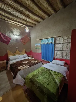 a bedroom with two beds in a room at Dar Gamra in Merzouga