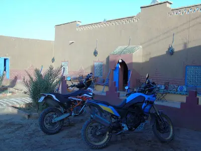 a motorcycle parked in front of a building at Dar Gamra in Merzouga