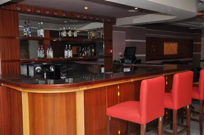 a bar with red chairs in a room at Across Hotels & Spa in Fès