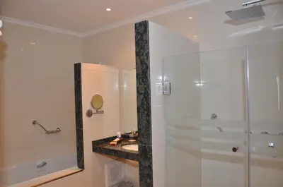 a white bathroom with a shower and a sink at Across Hotels & Spa in Fès