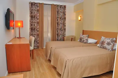 a hotel room with two beds and a television at Across Hotels & Spa in Fès