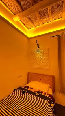 a bedroom with a bed with a light on the ceiling at Miguirne Chez Ali in Tamellalt