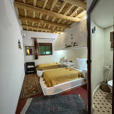 a bedroom with two beds in a room at Miguirne Chez Ali in Tamellalt
