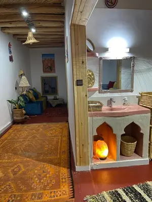 a living room with a sink and a fireplace at Miguirne Chez Ali in Tamellalt