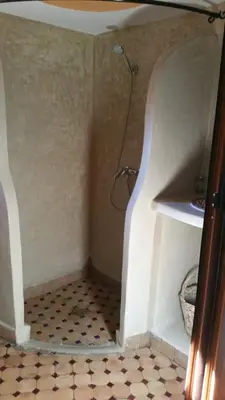 a bathroom with a shower with a tile floor at Miguirne Chez Ali in Tamellalt