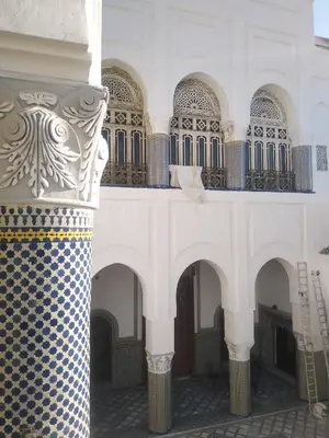 a building with a tiled wall and a balcony at suite in a XVIIIe palace in Fès