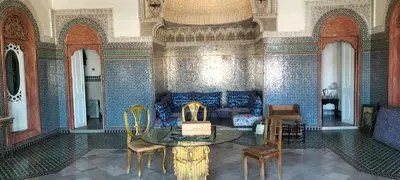 a room with a couch and a table and chairs at suite in a XVIIIe palace in Fès