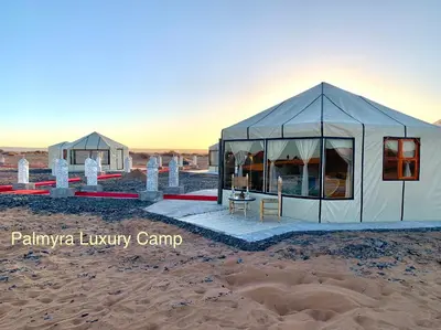 a couple of tents in the desert at Palmyra Luxury Camp in Merzouga