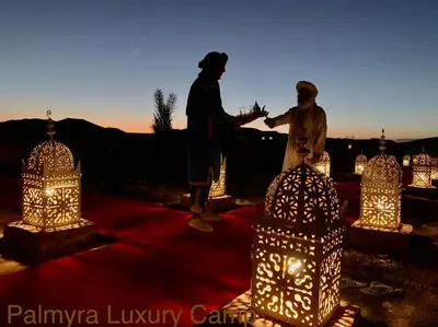 a couple of people standing next to a group of lights at Palmyra Luxury Camp in Merzouga